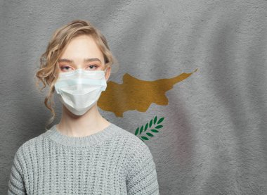 Kıbrıs bayrağıyla yüz maskesi takan genç bir kadın. Grip salgını ve virüs koruma kavramı