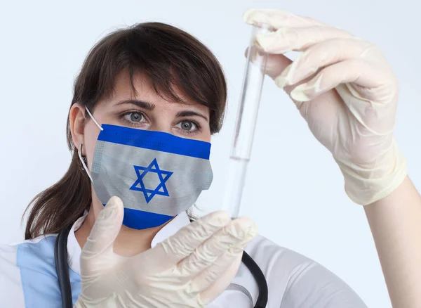 拿着以色列国旗的女科学家和面罩预防以色列大流行病的实验室病毒研究 — 图库照片