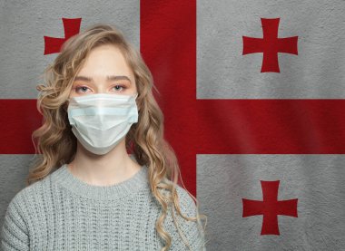 Ulusal Gürcistan bayrağıyla yüz maskesi takan genç bir kadın. Grip salgını ve virüs koruma kavramı