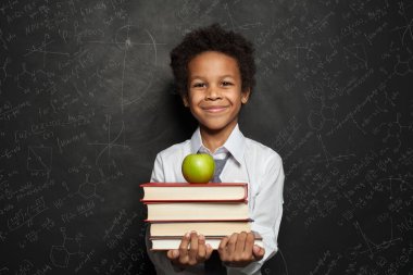 Küçük siyah çocuk gülümsüyor ve mavi arka plana bakıyor.