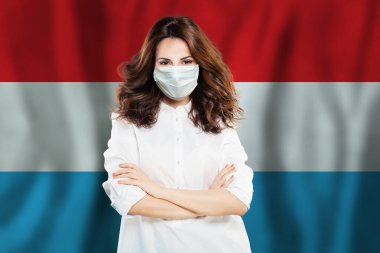Lüksemburg bayrağına karşı yüz maskeli hemşire. Grip salgını ve virüs koruma kavramı
