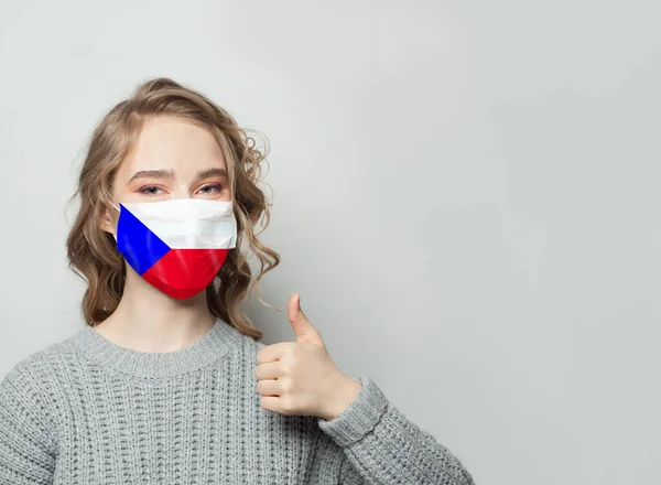 戴面具的快乐女人举着大拇指 有捷克共和国国旗的背景 流感流行与病毒防护概念 — 图库照片