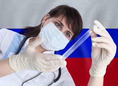 Test tüpü Coronavirus veya COVID-19 'u Rusya bayrağına karşı olan bilim kadını. Rusya 'daki bir salgının önlenmesi için laboratuvarda virüs araştırması