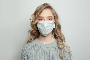 Beyaz arka planda yüz maskesi takmış güzel bir kadın. Tıbbi maskeli kadın. Grip salgını ve virüs koruma kavramı