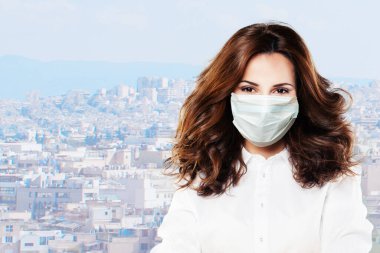 Yüzünde maske olan mutlu iyimser doktor kadın arka planda.