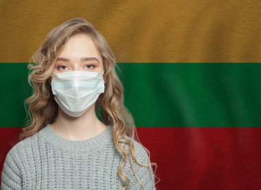 Litvanya bayrağıyla yüz maskesi takan genç bir kadın. Grip salgını ve virüs koruma kavramı