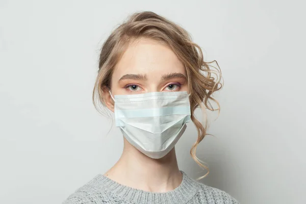 Young woman in a face mask on white background. Woman in medical mack. Flu epidemic and virus protection concept