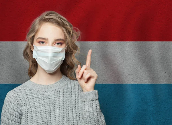 Frau Medizinischer Maske Zeigt Auf Den Hintergrund Der Luxemburgischen Nationalflagge — Stockfoto