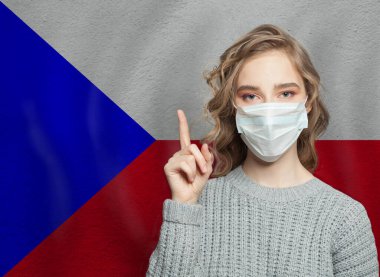 Sağlık maskeli bir kadın ulusal Çek Cumhuriyeti bayrağına işaret ediyor. Grip salgını ve virüs koruma kavramı