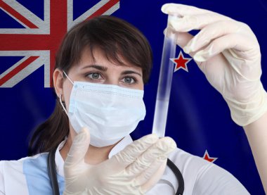Yeni Zelanda bayrağına karşı Coronavirus veya COVID-19 deneyleri yapan bilim kadını. Yeni Zelanda 'daki bir salgının önlenmesi için laboratuvarda virüslerin araştırılması