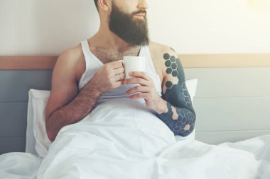Sakallı adam yatakta sabah kahve içme 
