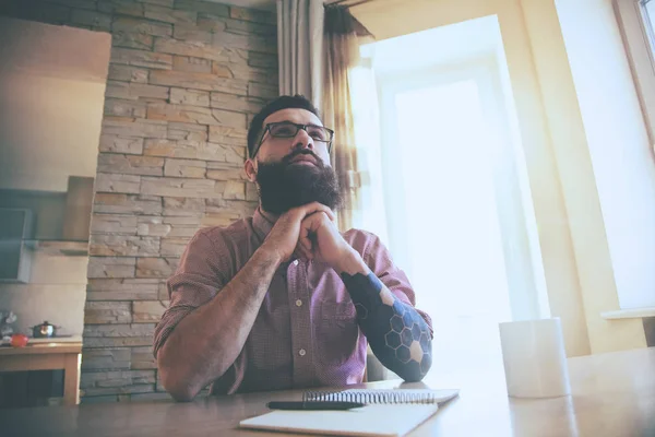 Bebaarde man met bril schrijven met pen — Stockfoto