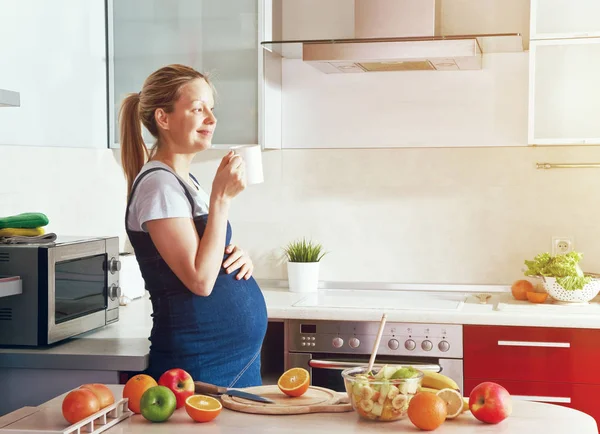 Femme enceinte buvant du thé dans la cuisine — Photo