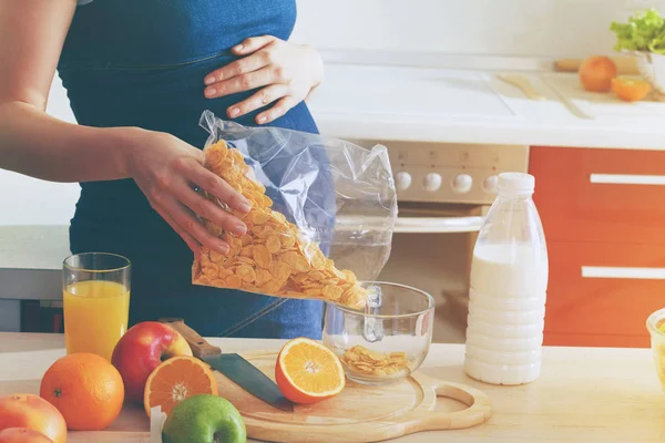 Femme enceinte faisant le petit déjeuner dans la cuisine — Photo