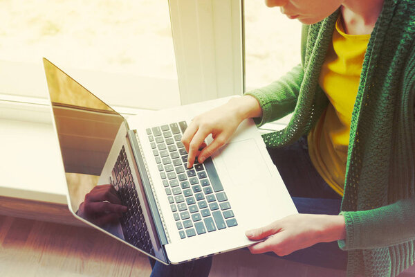 Женщина печатает на ноутбуке 