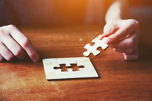 Mãos resolver quebra-cabeça puzzle — Fotografia de Stock