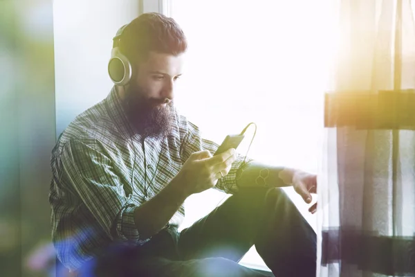 Brodaty mężczyzna w słuchawki do słuchania muzyki — Zdjęcie stockowe