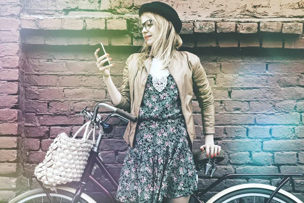 Wanita hipster dengan sepeda menggunakan smartphone — Stok Foto