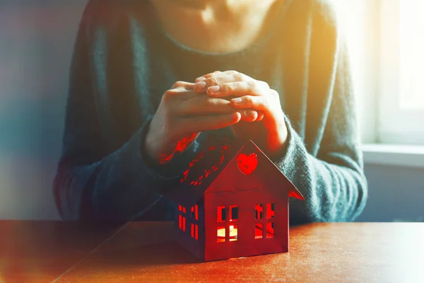 Händer skydda röd modell av hus — Stockfoto