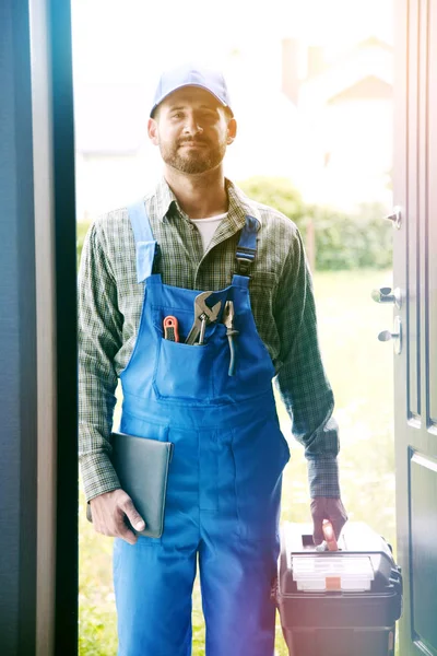 Service man standing on doorstep of house — Stock Photo, Image