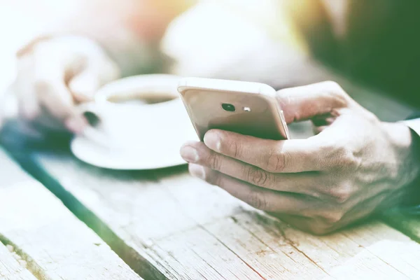 Affärsman innehav kaffe och telefon — Stockfoto