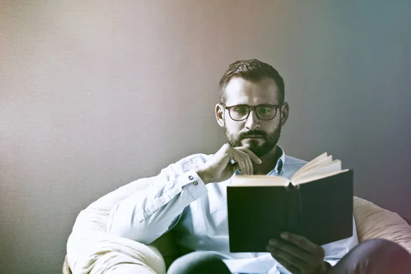 Hombre guapo leyendo libro interesante . — Foto de Stock