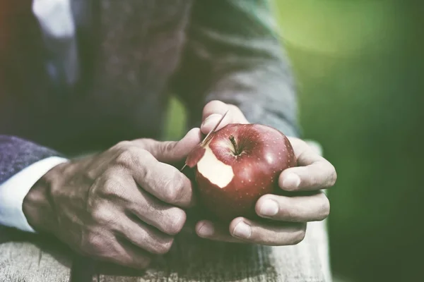Male hands peeling red apple — Stock Photo, Image