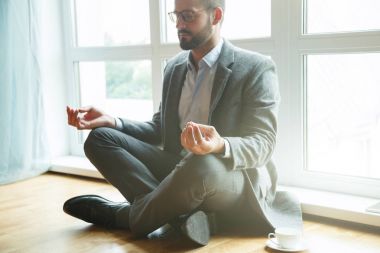 Lotus poz yoga yaparken işadamı