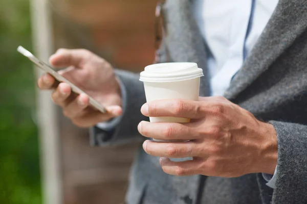 Affärsman Hand Hålla Morgonkaffe Och Läsande Telefonerna — Stockfoto