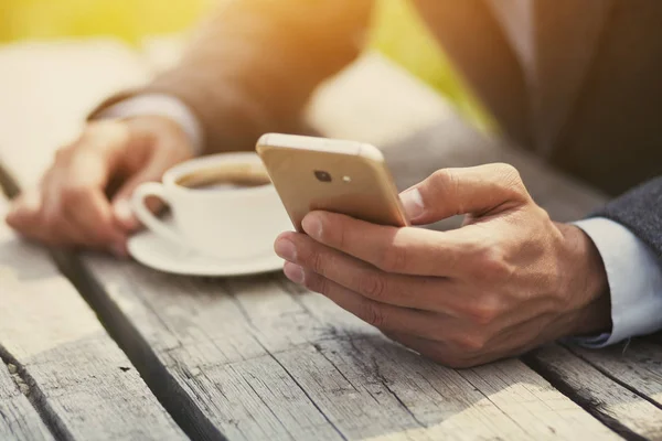 Affärsman Hand Hålla Morgonkaffe Och Läsande Telefonerna — Stockfoto