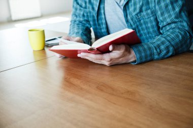fincan çay veya kahve evde kitap okurken erkek