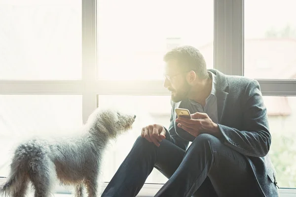 Geschäftsmann Nutzt Smartphone Auf Hellem Hintergrund Spielt Mit Hund — Stockfoto