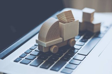 Laptop klavye üzerinde ahşap oyuncak kamyon. Internet alışveriş, on-line satın, e-ticaret ve paketleri teslim kavramı.