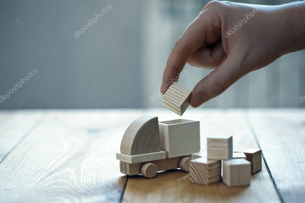 Wooden model of truck, hand loading freight. Shipping and delivery concept