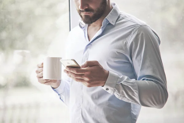 Biznesmen Posiadający Poranną Kawę Czytanie Telefon — Zdjęcie stockowe