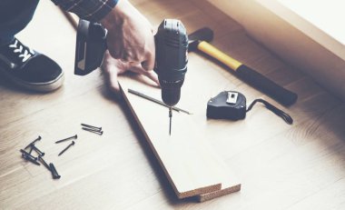 adamın elleri elektrikli tornavida ve ahşap tahta çalışma yakından görmek