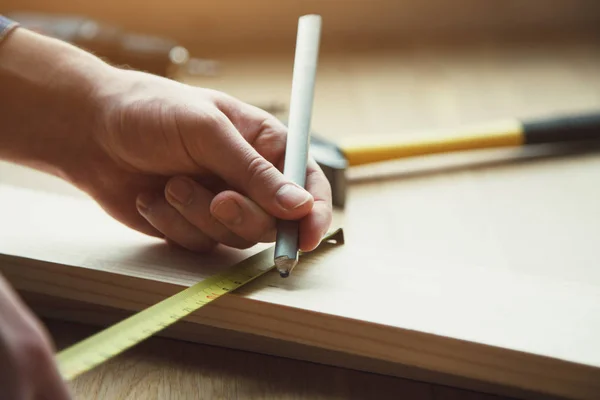 男の手を測定テープと鉛筆でマーキングの木材での作業のクローズ アップ ビュー — ストック写真