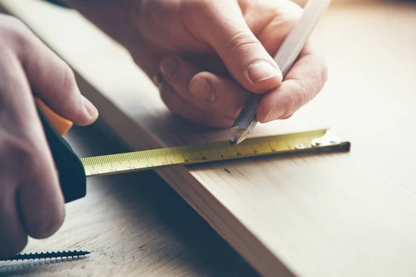 男の手を測定テープと鉛筆でマーキングの木材での作業のクローズ アップ ビュー — ストック写真
