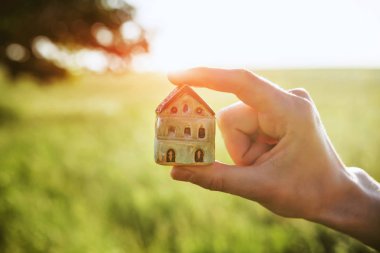 Sembol olarak ev modelini tutan eller