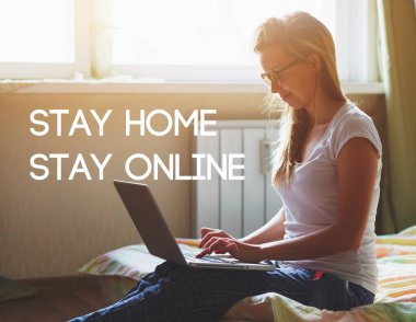 Sabahları dizüstü bilgisayarı olan bir kadın yatakta oturuyor ve 