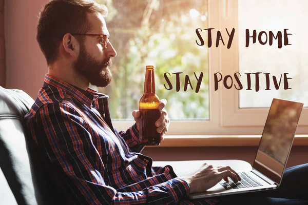 Hombre Barbudo Con Portátil Bebiendo Botella Cerveza Texto Quédese Casa —  Fotos de Stock