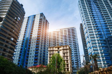 Yüksek modern mimariyle çevrili küçük bir ev. Farklı binaların karşıtlığı. 