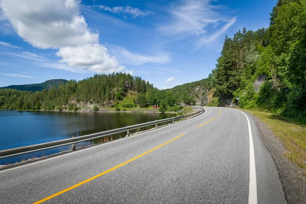 Strada curva vuota sulla riva dei laghi in Norvegia — Foto Stock