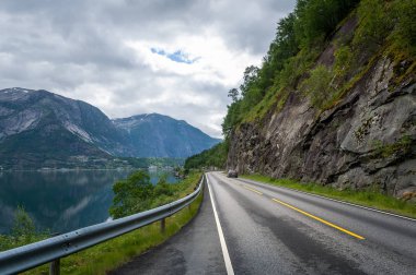Fiyort su ve sarp dağ arasındaki doğal Norveç yol