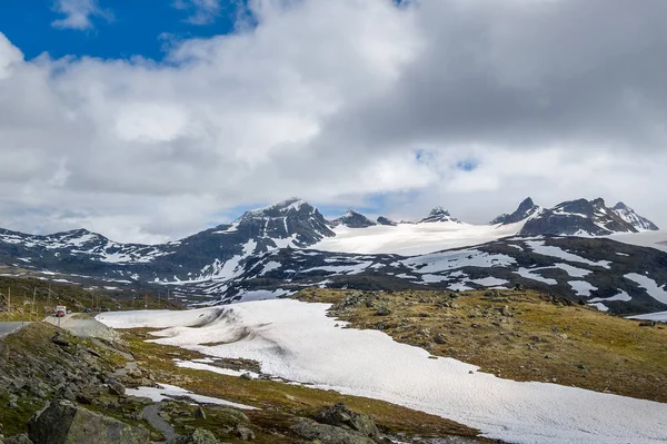 Strada nelle montagne rocciose innevate, Norvegia . — Foto Stock