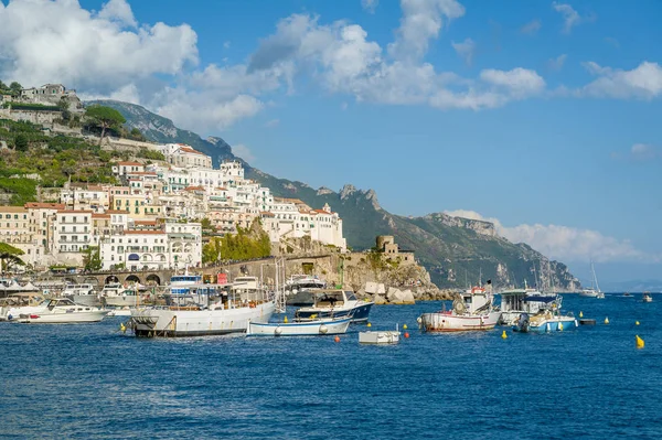 Amalfi-Stadt auf den Hügeln und Fischerboote Stockbild