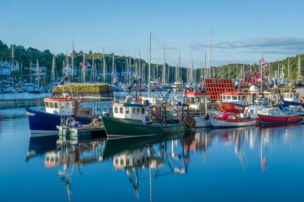 Belo dia calmo no porto de Tarbert. Loals coloridos barcos e reflexões de água . — Fotografia de Stock