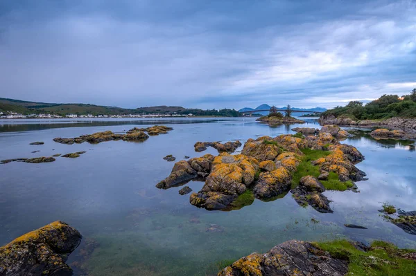 Pôr do sol paisagem marinha com rochas na água e Skye ilha no fundo . — Fotografia de Stock