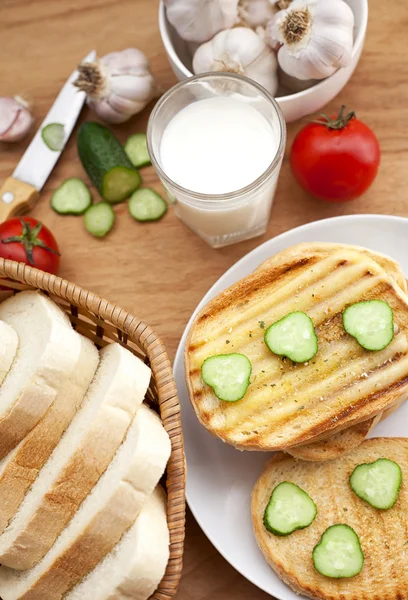 Pişmiş ekmek, süt ve sebze kahvaltı için — Stok fotoğraf
