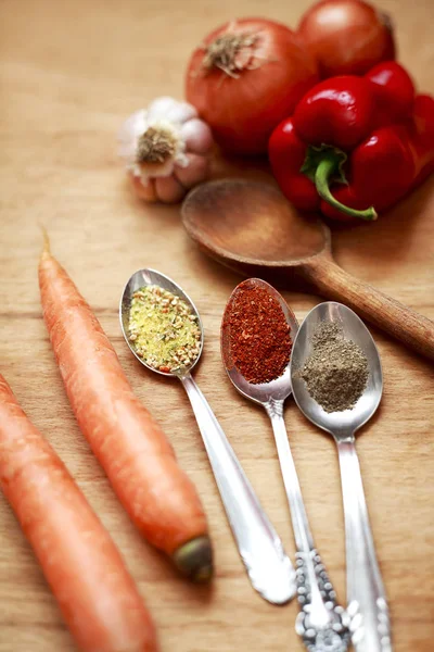 Gewürze und frisches Gemüse auf einem Holztisch — Stockfoto